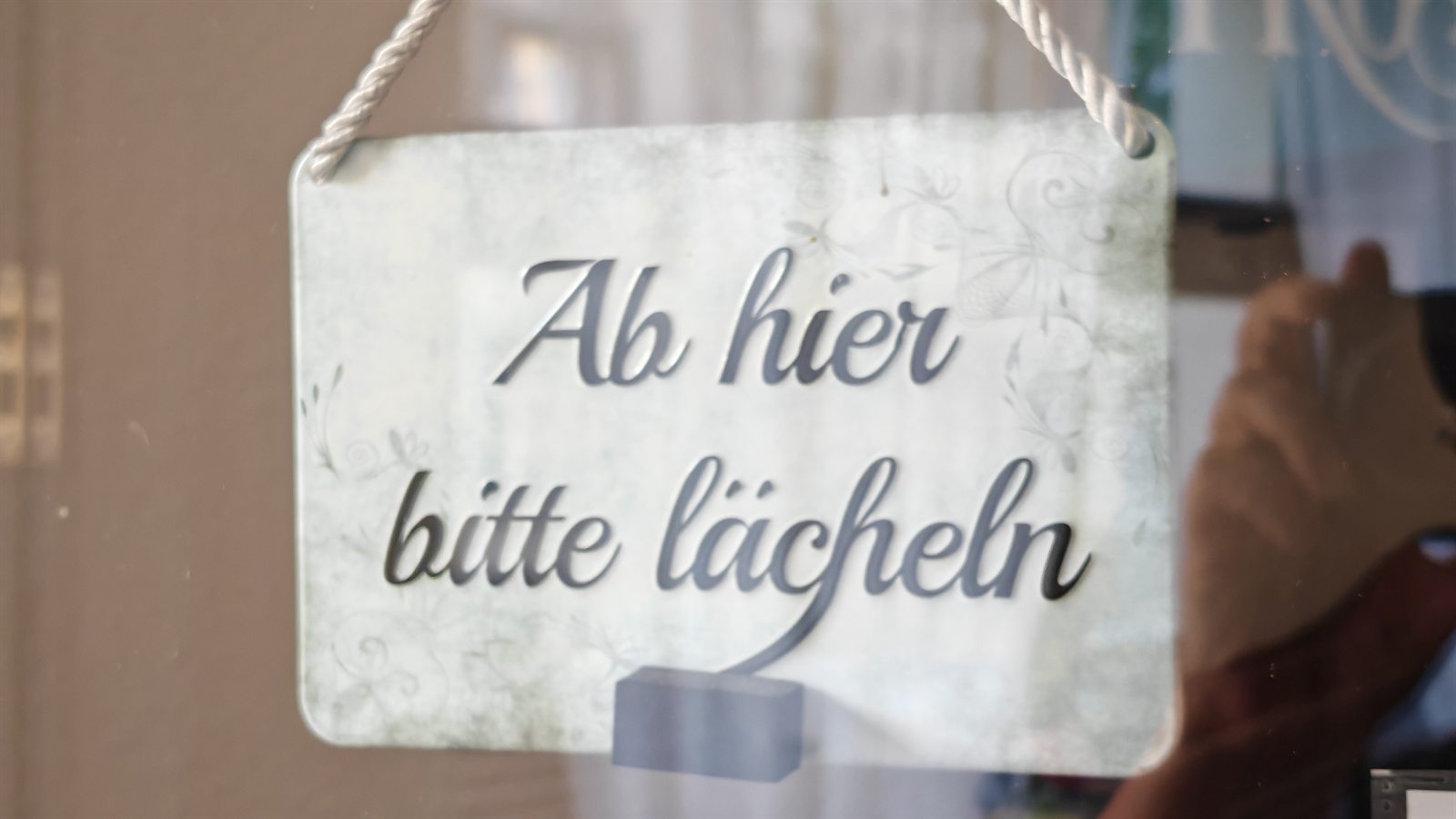 Schild im Salon mit der Aufschrift Ab hier bitte lächeln